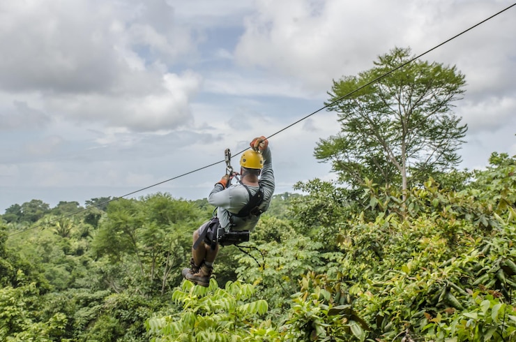 close-up-shot-man-hanging-sliding-zipline-beautiful-park-cloudy-sky_181624-59193