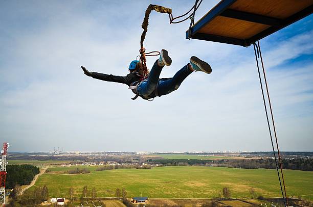 Ropejumping: girl jumping from a height in the equipment for mountaineering and helmet