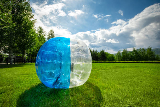 Zorbing Balloon on the summer lawn. inflatable zorb ball outdoor. Leisure activity concept with copy space.
